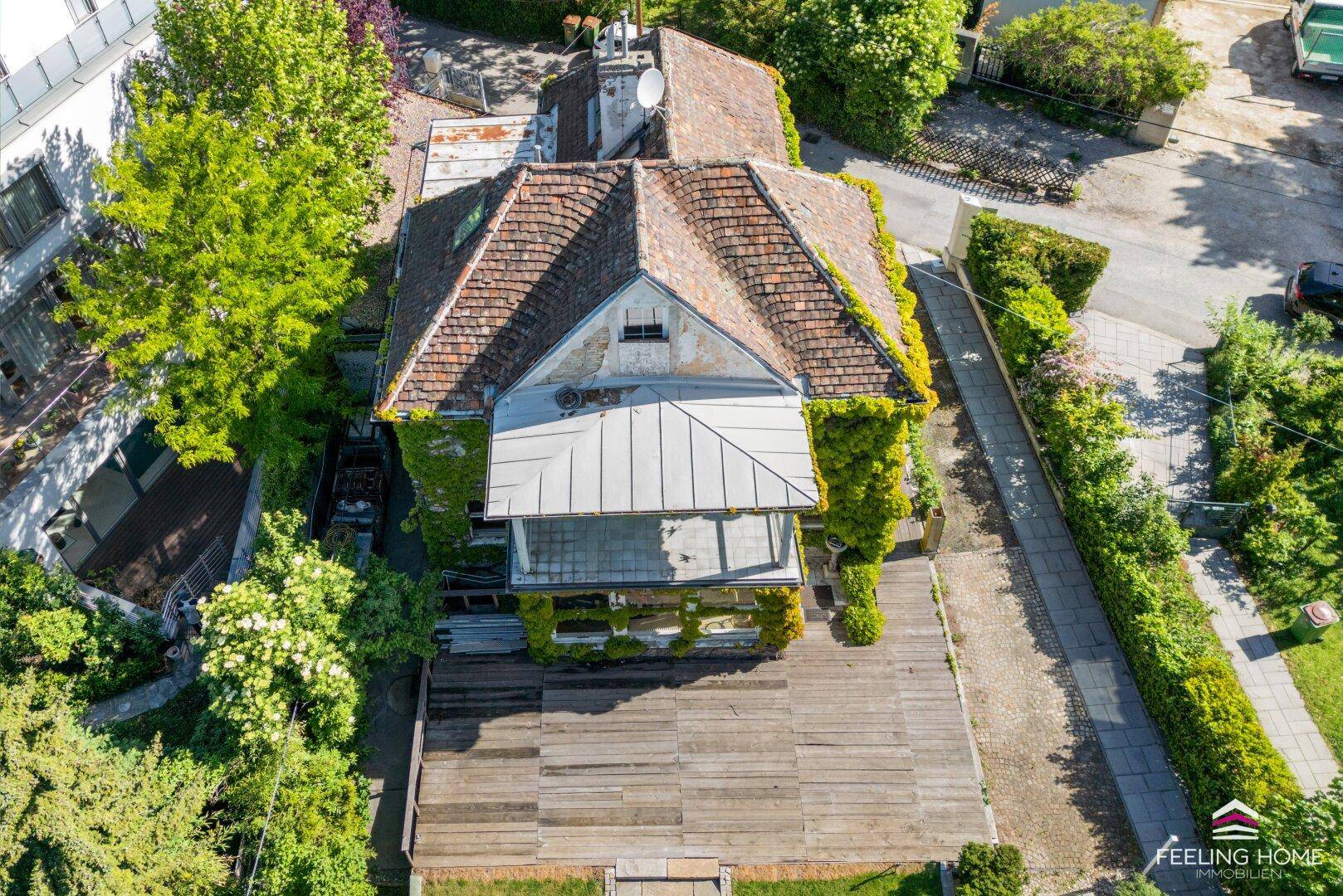 Luftaufnahme des Anwesens mit Dach, Garten und umliegender grüner Landschaft.