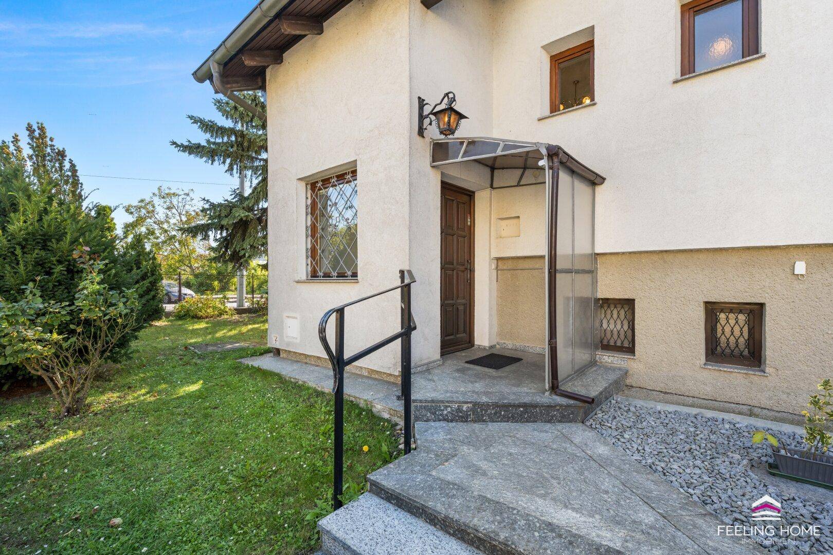 Eingangsbereich des Hauses mit Überdachung, Treppe und Geländer.