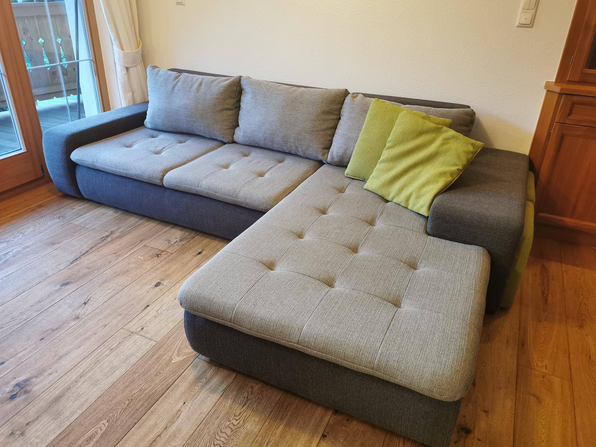 Geräumiges Ecksofa mit bequemen Kissen in einem hellen Wohnzimmer.