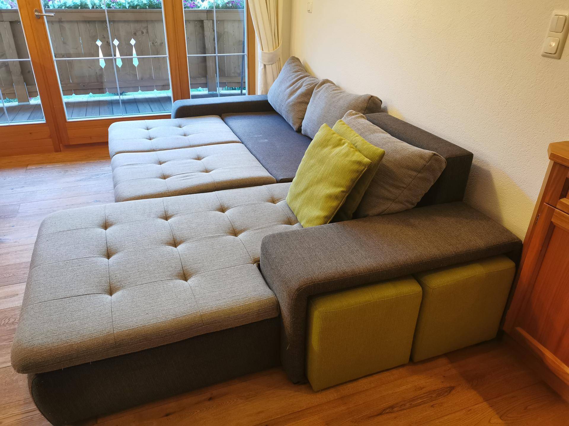 Gemütliches Ecksofa mit bequemen Kissen in einem hellen Wohnzimmer.