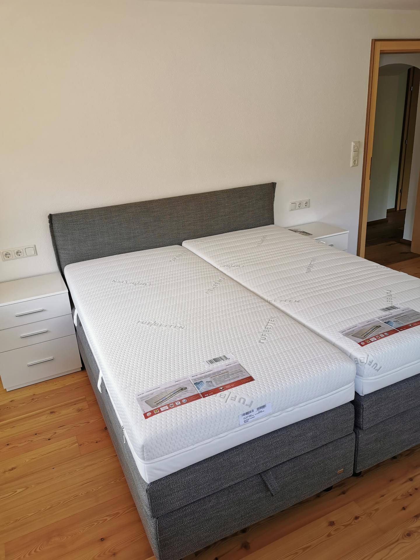 Schlafzimmer mit Doppelbett und Nachttischen, bereit für die Einrichtung.