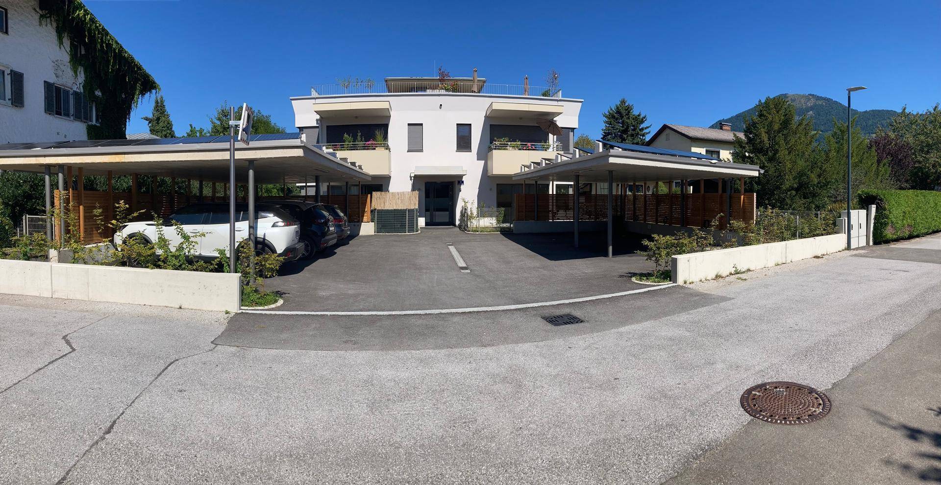 Moderne Wohnanlage mit mehreren Carports und Zufahrt von der Straße.
