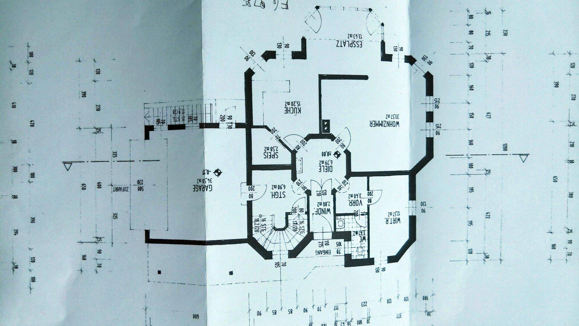 Grundriss des Erdgeschosses mit Küche, Wohnzimmer, Essbereich und Garage.