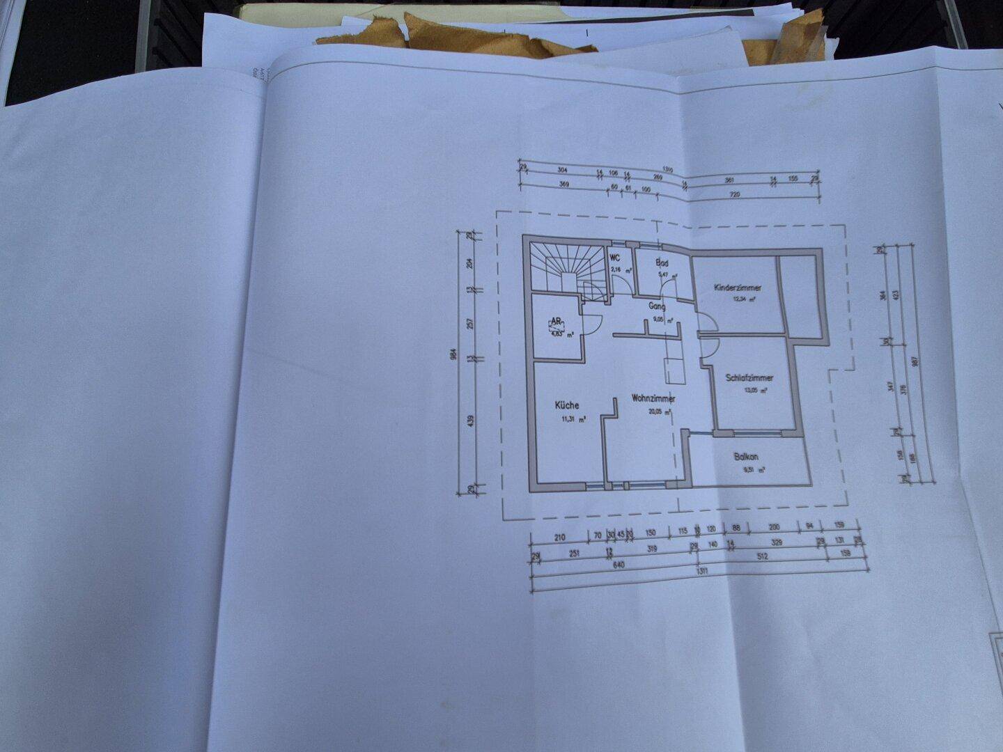 Grundrissplan mit Küche, Wohnzimmer, Schlafzimmer, Bad und Balkon.