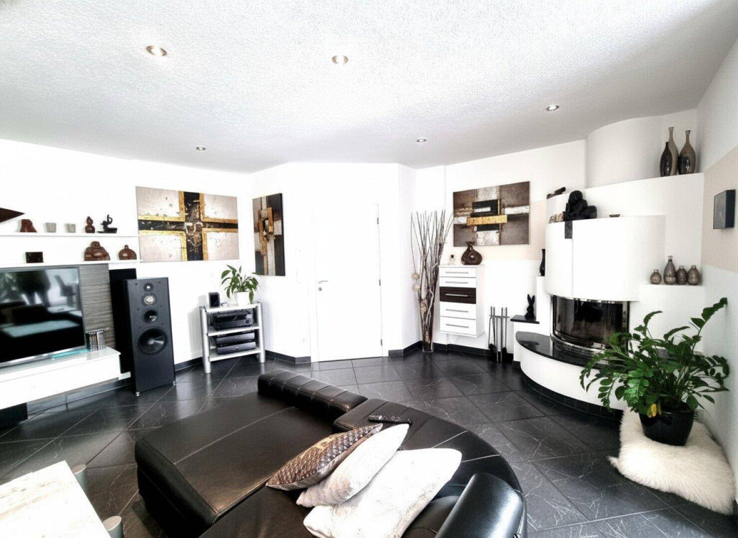 Gemütliches Wohnzimmer mit modernem Kamin, dunklen Fliesen und stilvoller Dekoration.