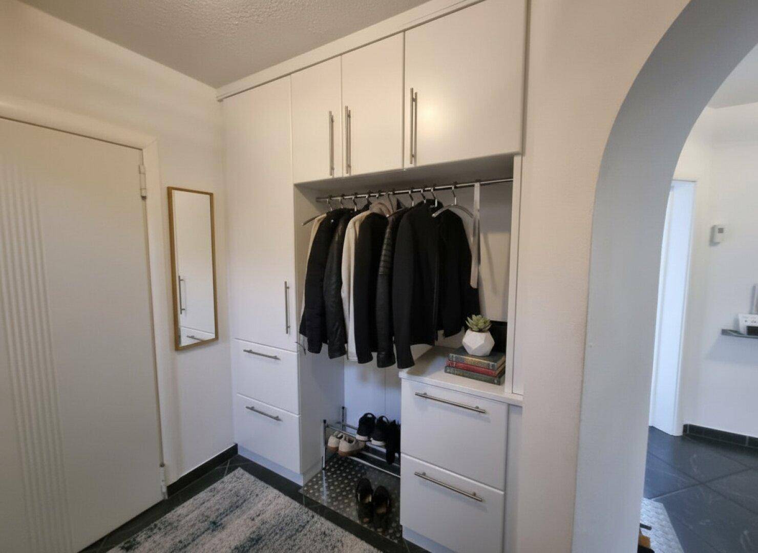 Praktische Einbauschränke im Flur bieten viel Stauraum für Kleidung und Schuhe.