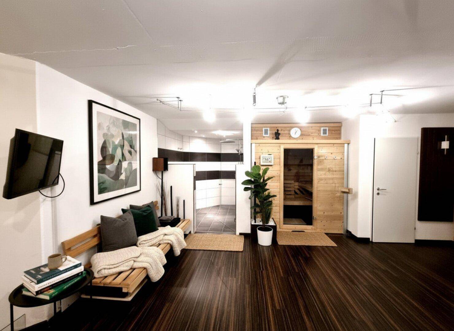 Entspannender Wellnessbereich mit Sauna, Holzbänken und dunklem Boden, ideal zur Erholung.