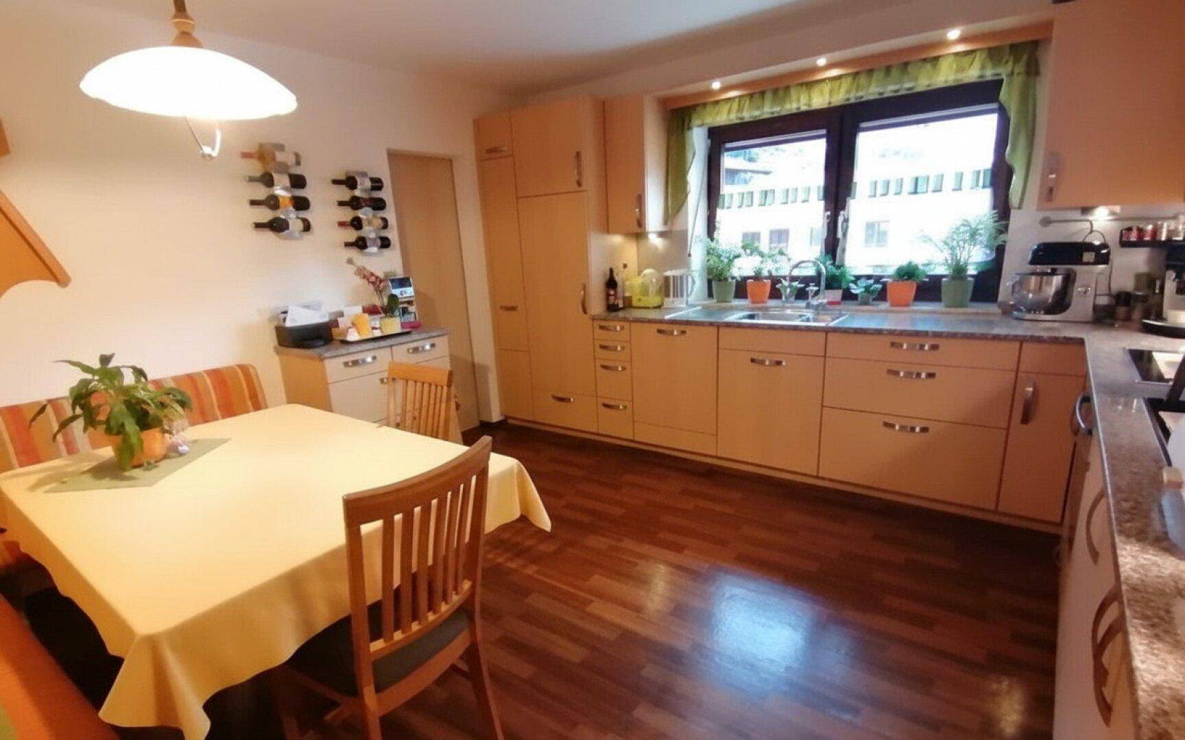 Geräumige Küche mit Fenster über der Spüle, Essbereich und viel Stauraum.