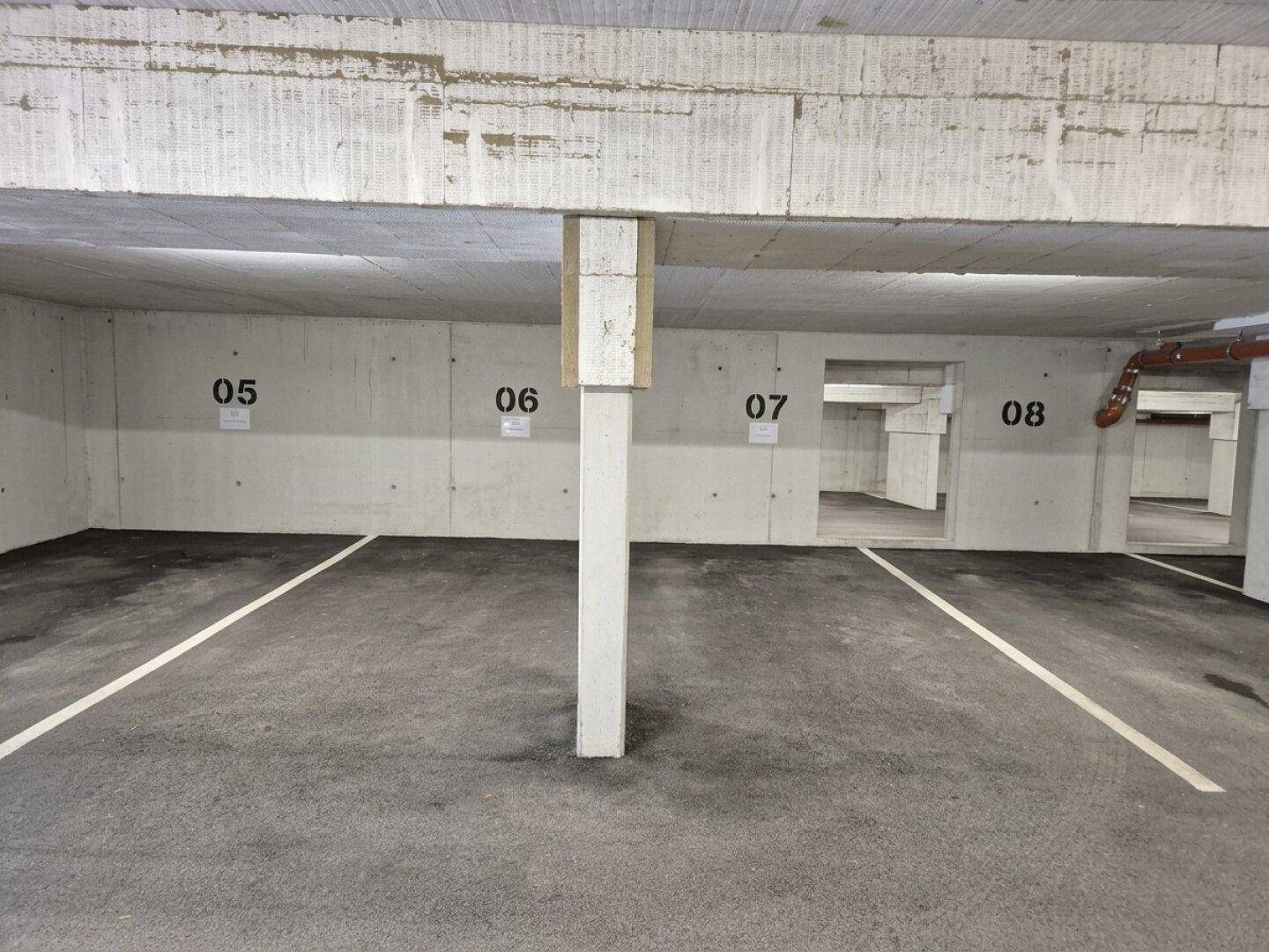 Tiefgarage mit nummerierten Stellplätzen und solider Betonkonstruktion.