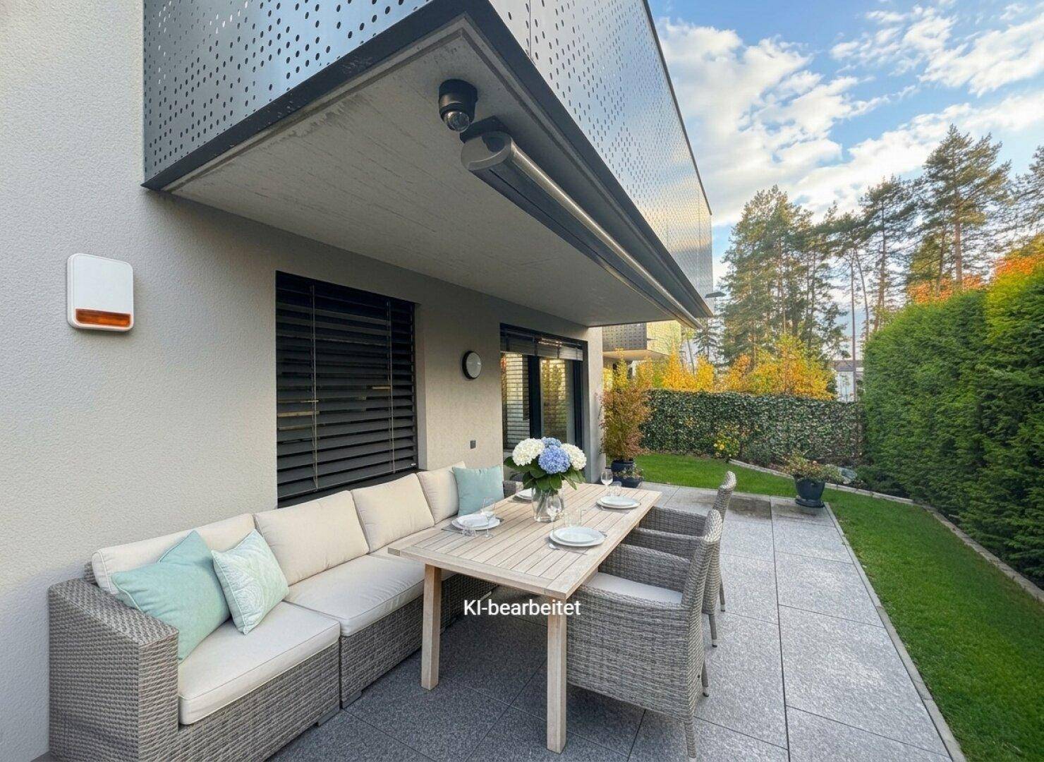 Gemütliche, möblierte Terrasse mit Essbereich und Lounge-Sofa unter einem Balkon.