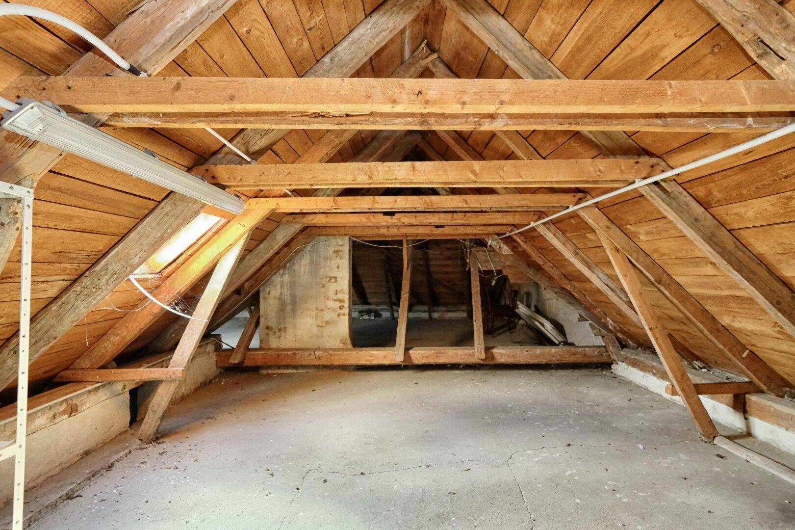 Unausgebauter Dachboden mit sichtbaren Holzbalken und viel Potenzial für zukünftige Nutzung.