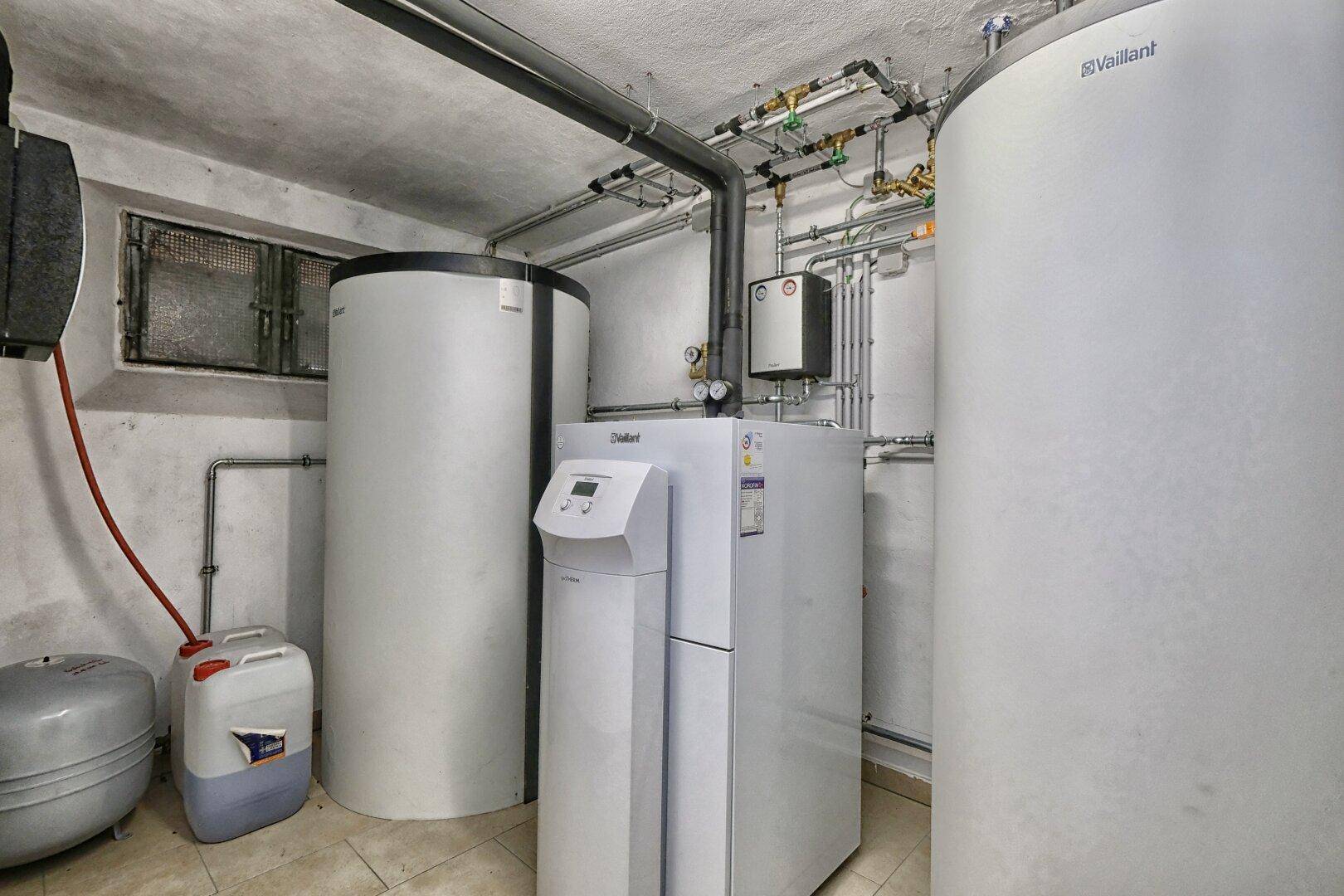 Heizungsraum im Keller mit modernen Heizungsanlagen und Warmwasserspeichern.