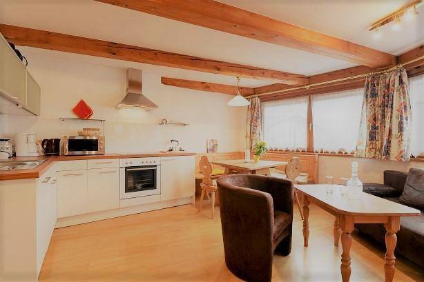 Kleine Küche mit Essbereich, Holzbalken und Blick auf die Umgebung.