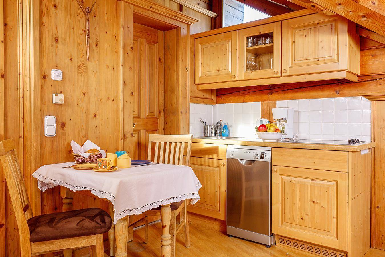 Kleine Holzküche mit Essbereich, Geschirrspüler und traditionellem Charme.