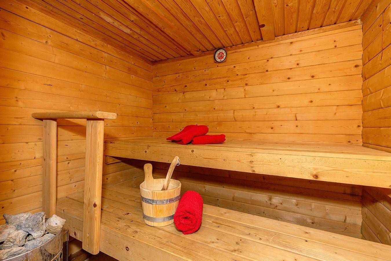 Traditionelle Holzsauna mit Bänken und typischem Zubehör für entspannende Momente.
