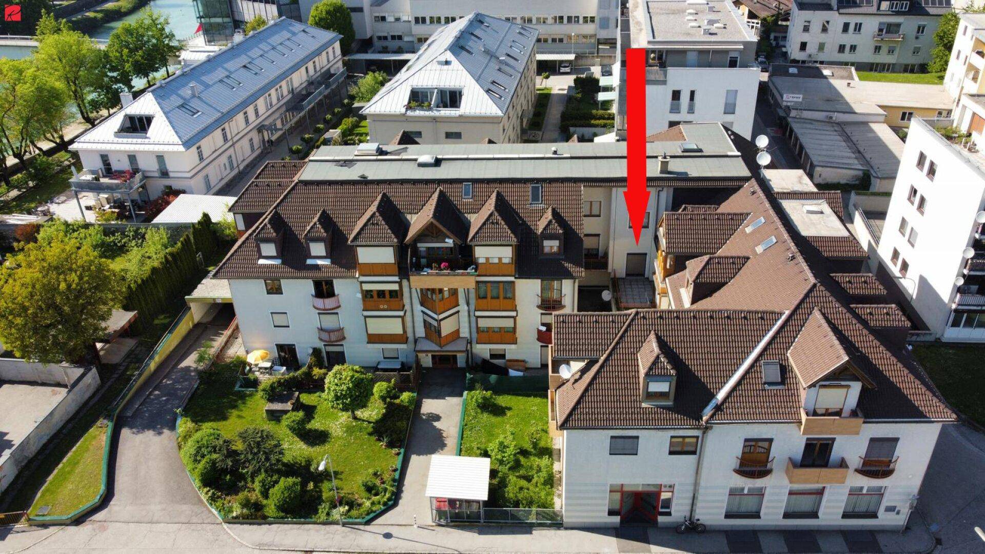 Luftaufnahme eines Wohngebiets mit Mehrfamilienhäusern und Grünflächen.