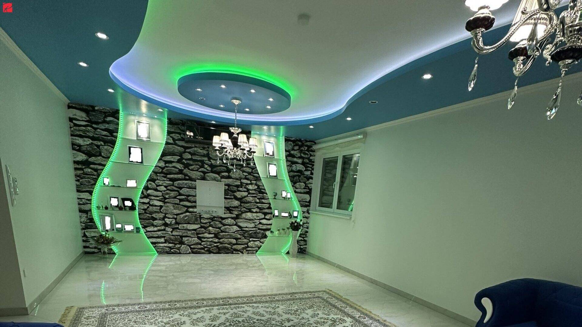 Auffälliges Wohnzimmer mit kreativer Deckenbeleuchtung, Steinwand-Akzent und elegantem Kronleuchter.