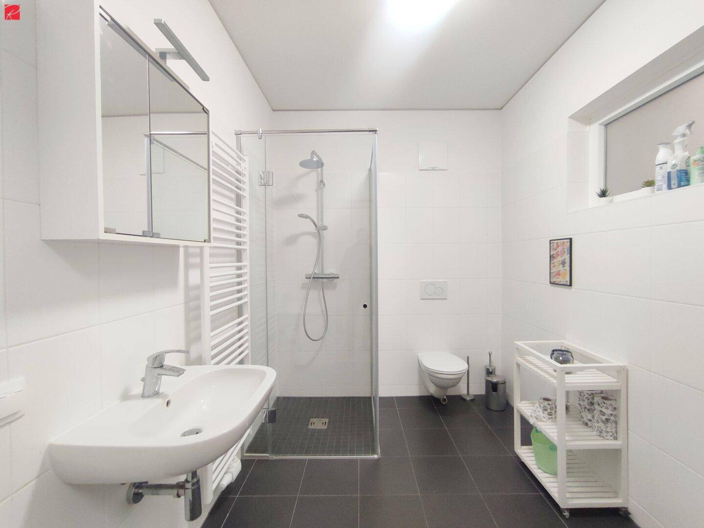 Modernes Badezimmer mit ebenerdiger Dusche, Wand-WC und Fenster.