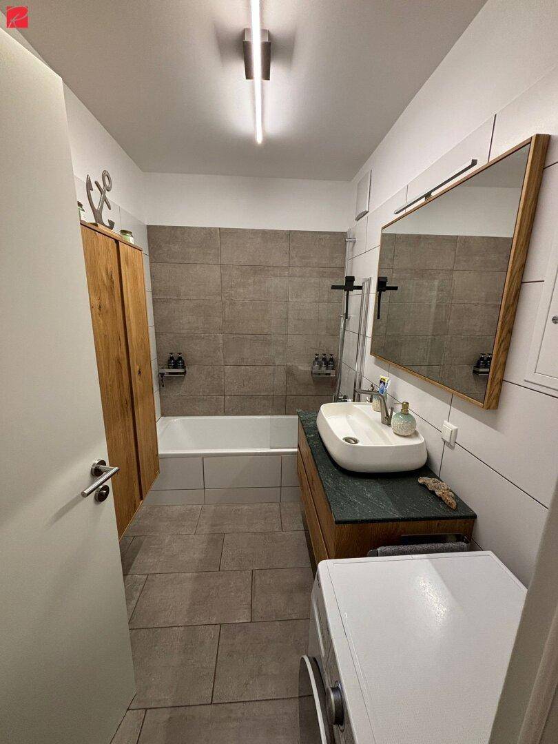 Modernes Badezimmer mit Badewanne, Dusche und stilvollem Waschbecken.
