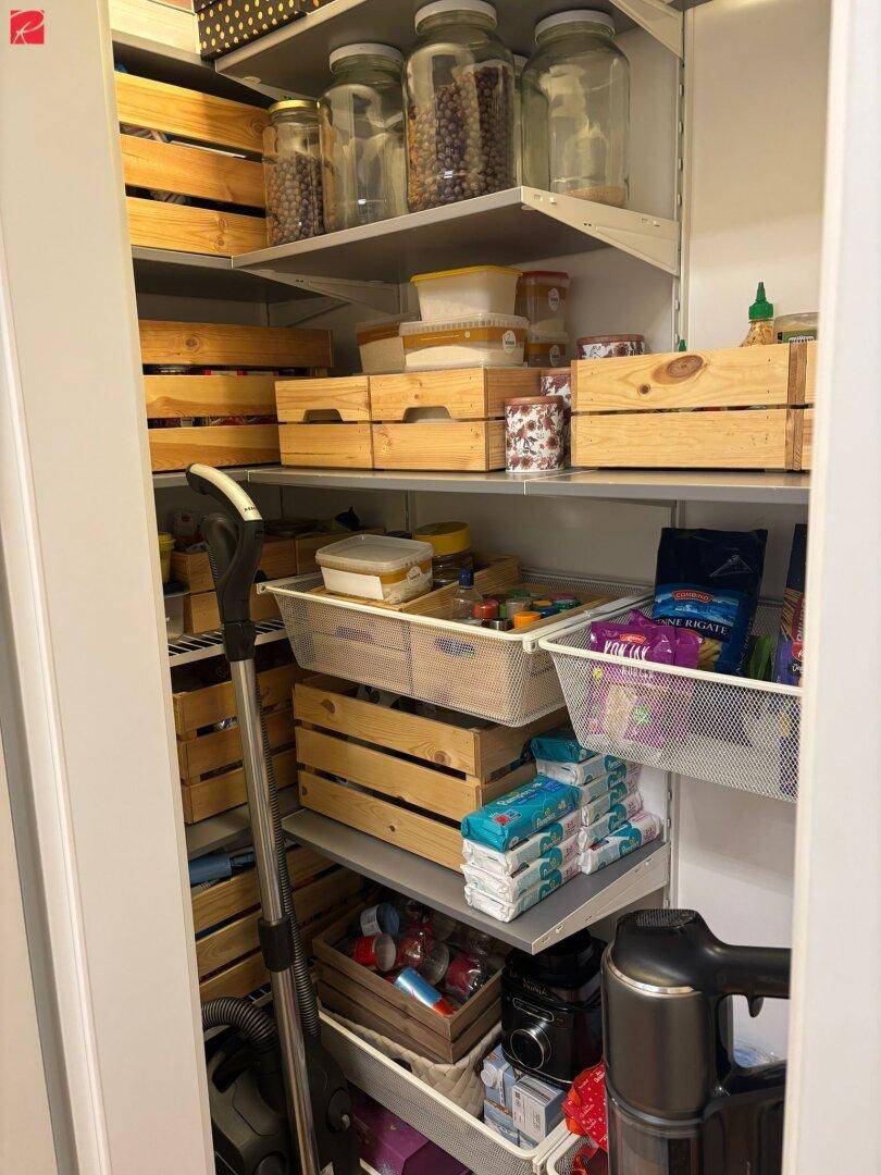 Praktischer Abstellraum mit Regalen, Holzkisten und Vorräten.