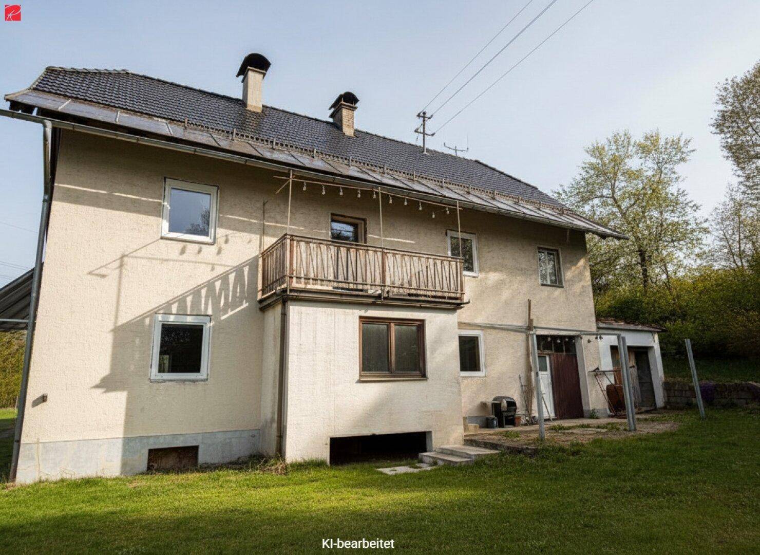 Ansicht der Hausrückseite mit Balkon, Gartenbereich und Zugang zum Kellergeschoss.