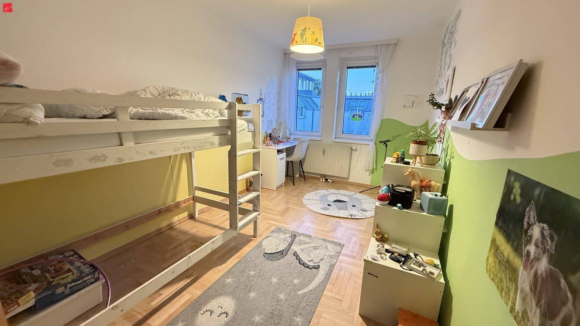 Farbenfrohes Kinderzimmer mit Etagenbett, Schreibtisch und spielerischer Dekoration.
