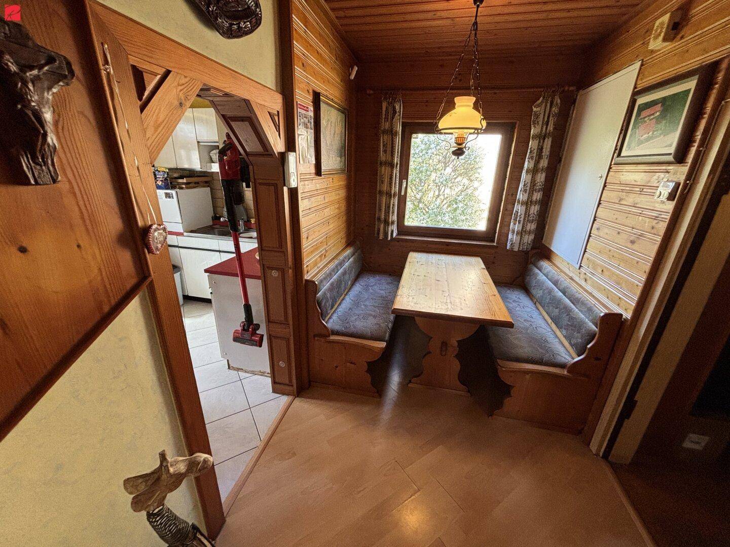 Traditionelle Essecke mit Holztäfelung, Eckbank und rustikalem Tisch.