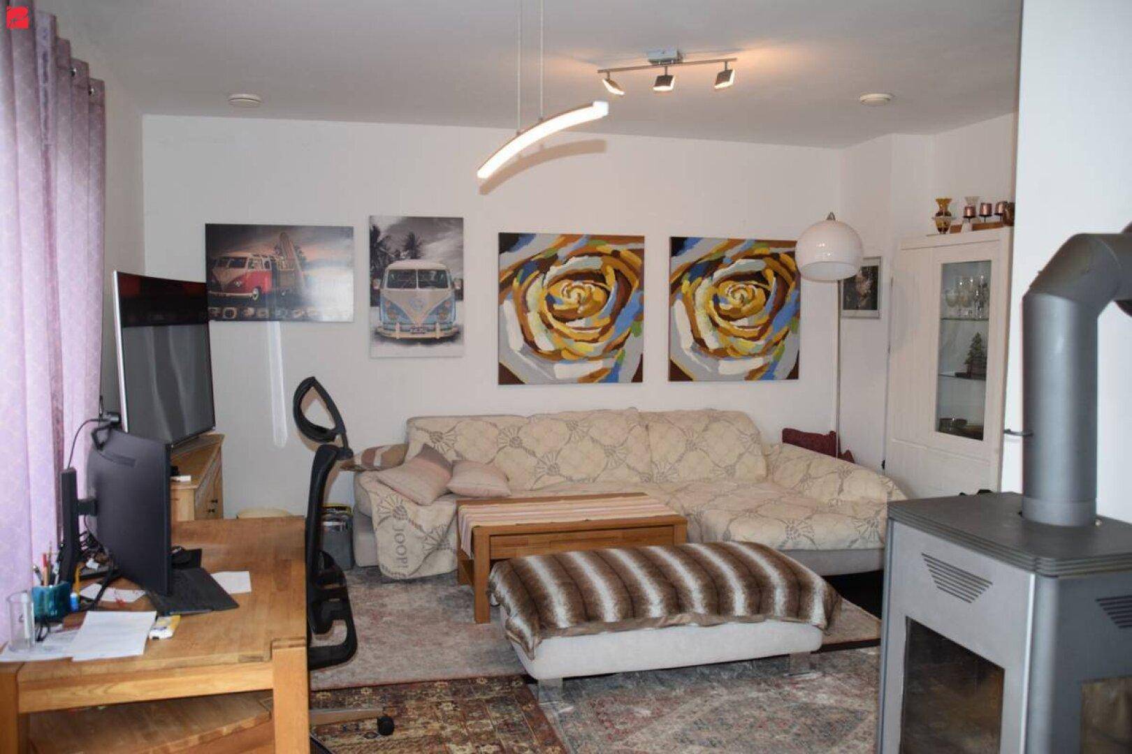 Helles Wohnzimmer mit Sofa, Kaminofen und modernem Dekor, ideal zum Entspannen.