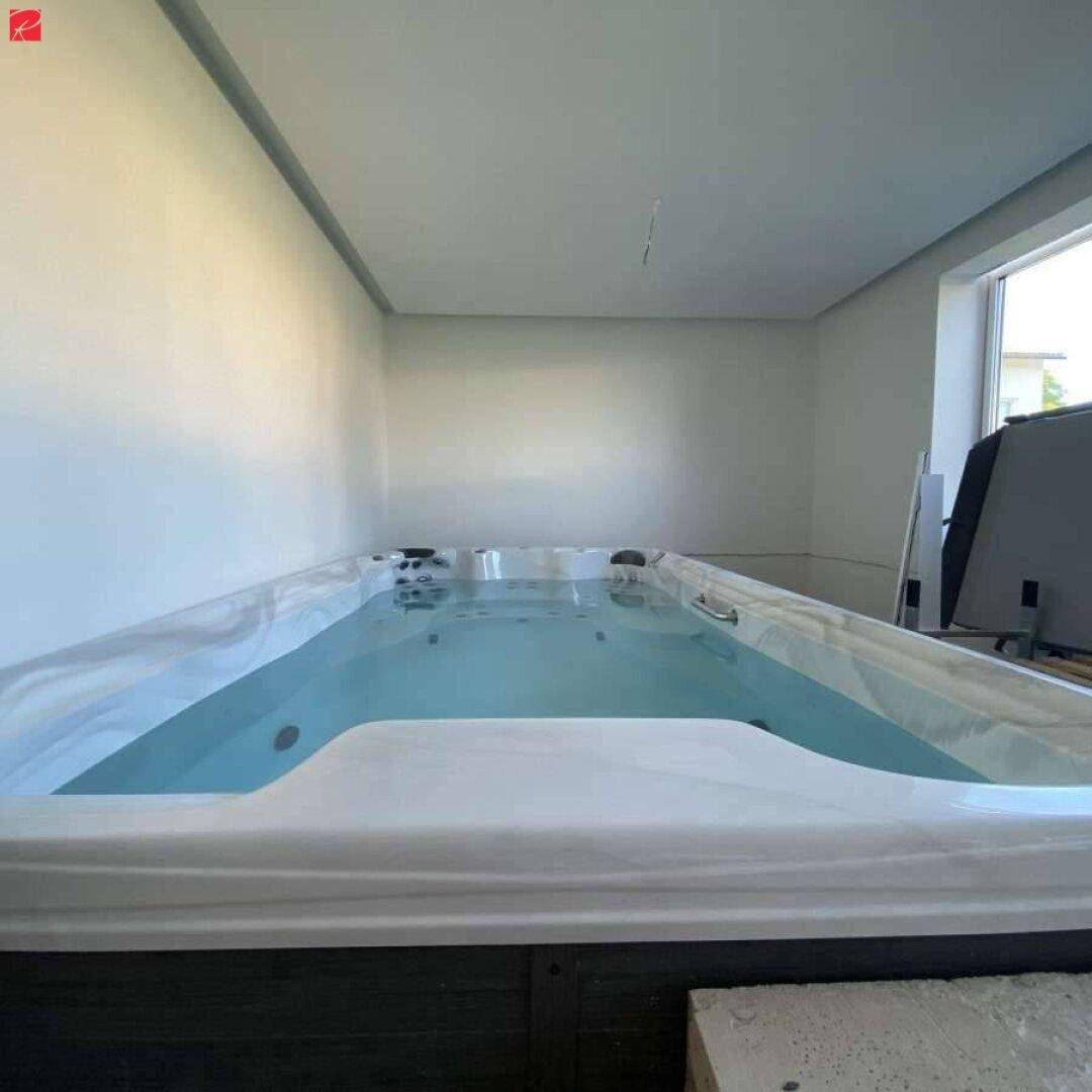 Langer Innenpool oder Schwimmkanal in einem hellen Raum mit großem Fenster.