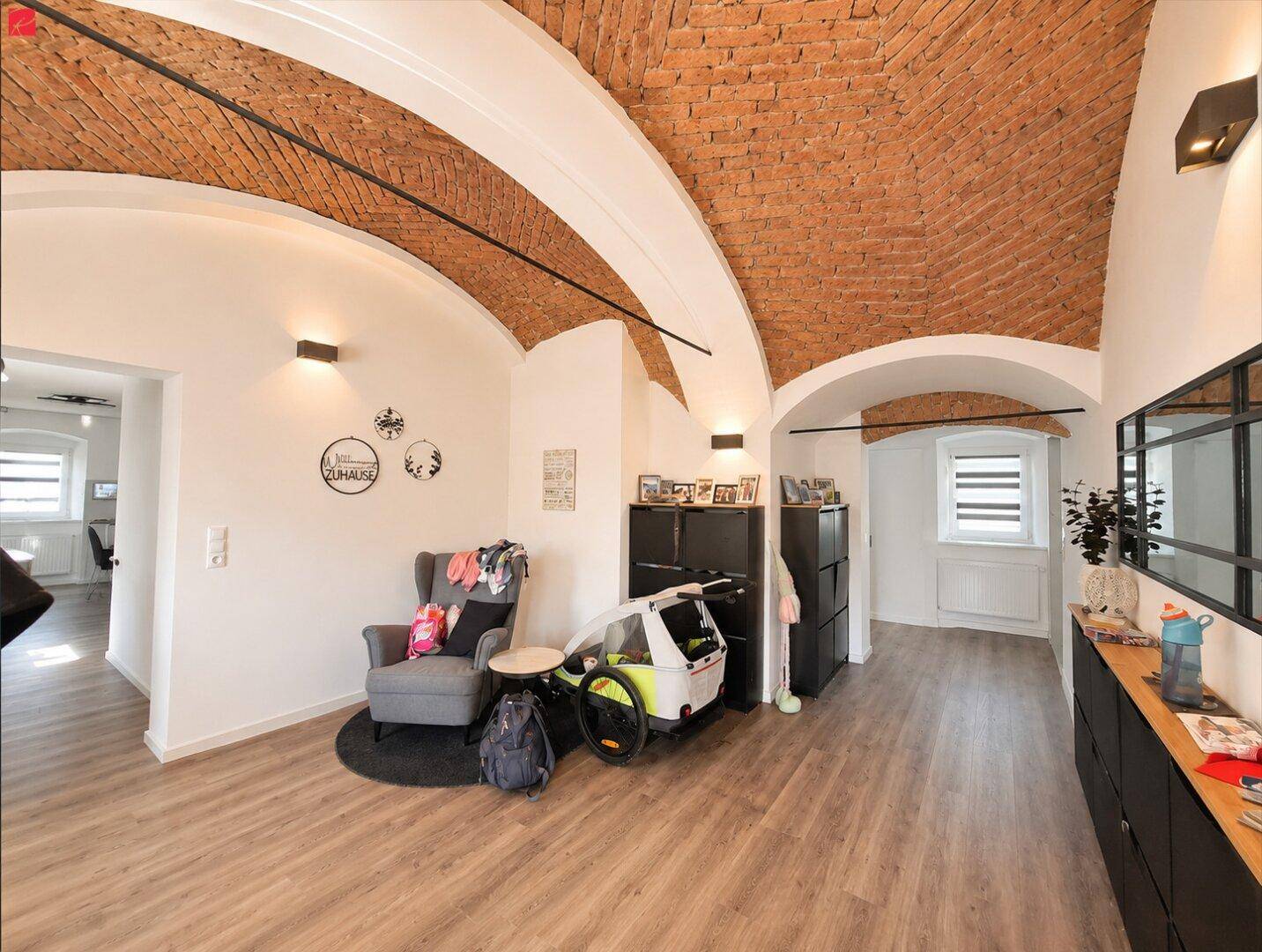 Historischer Raum mit beeindruckenden Gewölbedecken aus Backstein und modernem Laminatboden.