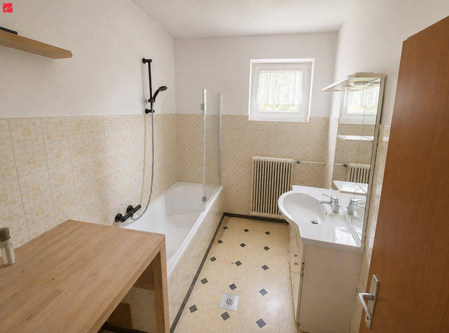 Badezimmer mit Badewanne, Duschfunktion, Einzelwaschbecken und Fenster für Tageslicht.
