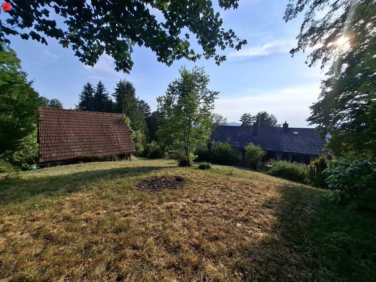 Malerisches Anwesen mit zwei Gebäuden und weitem Blick über die umliegende grüne Landschaft.