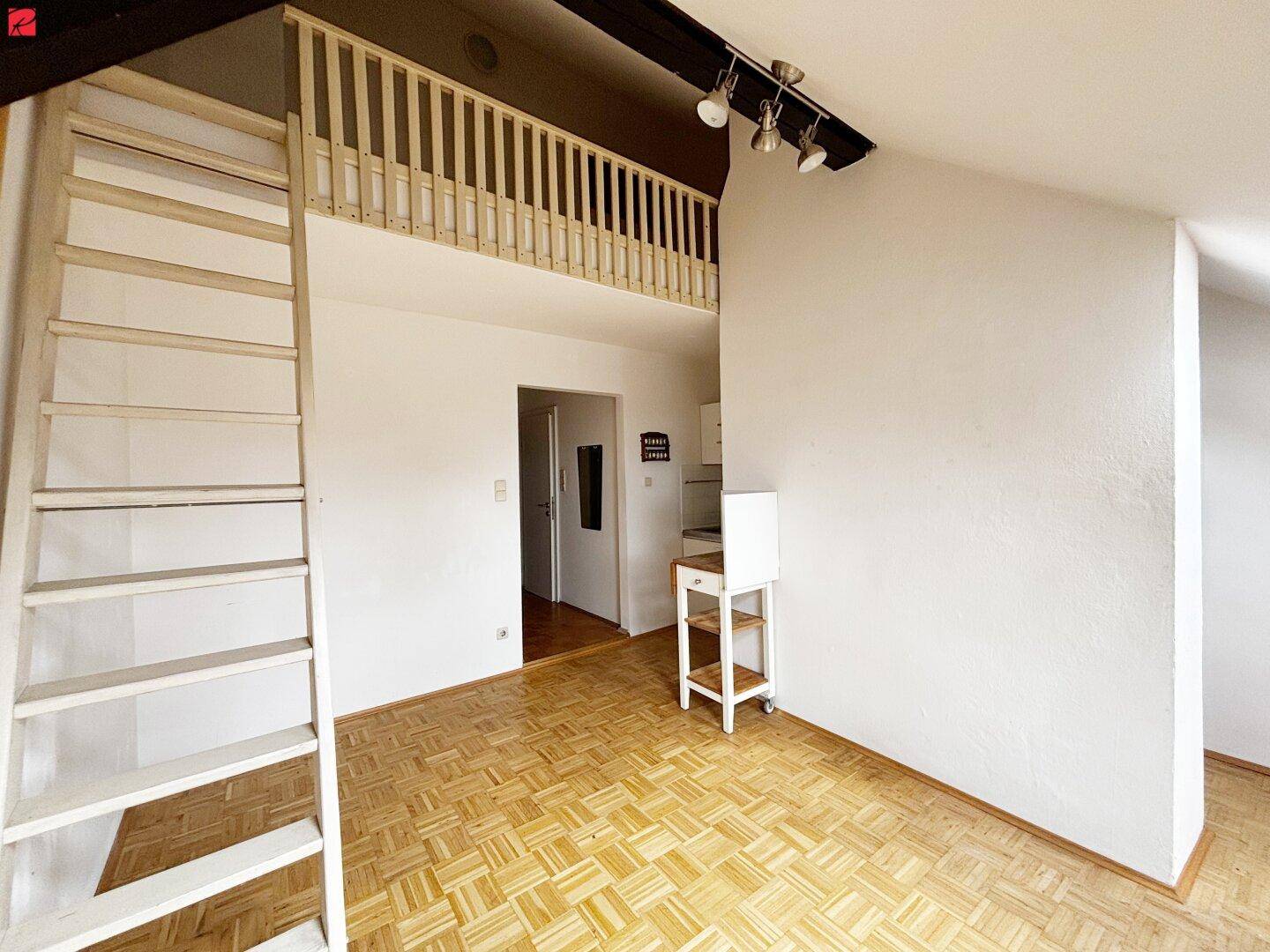 Heller Dachbodenraum mit Holzleiter zu einer Galerie und Holzboden.
