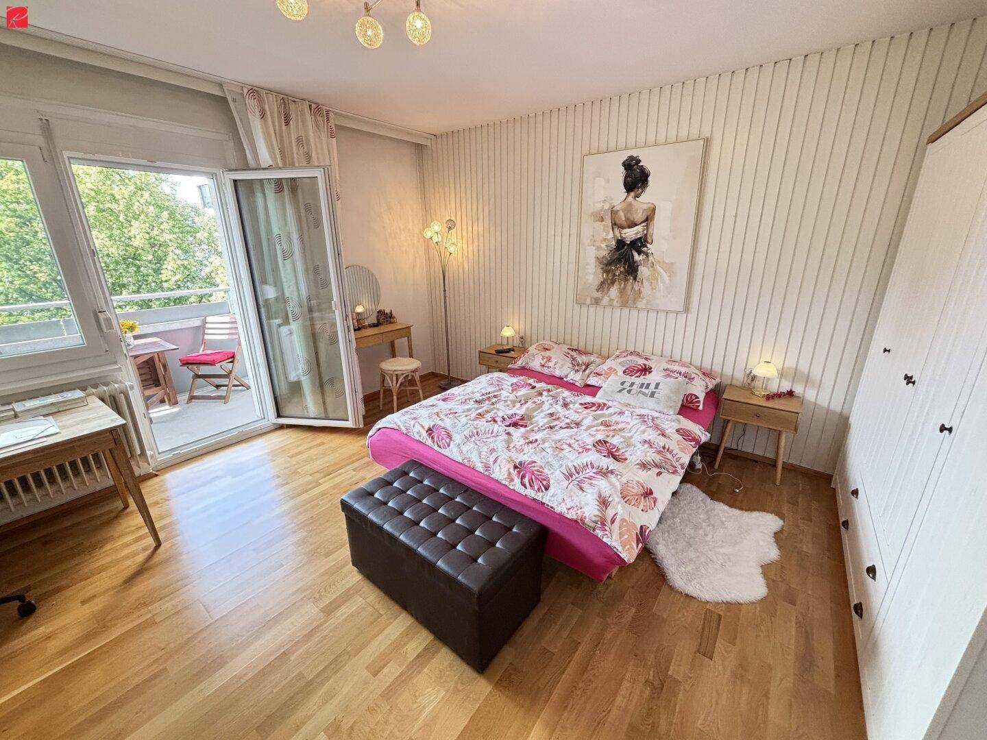 Gemütliches Schlafzimmer mit Holzboden, Doppelbett und direktem Zugang zum Balkon.