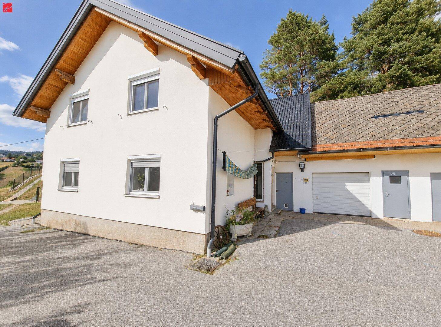 Modernes Einfamilienhaus mit weißer Fassade, Satteldach und integrierter Garage.
