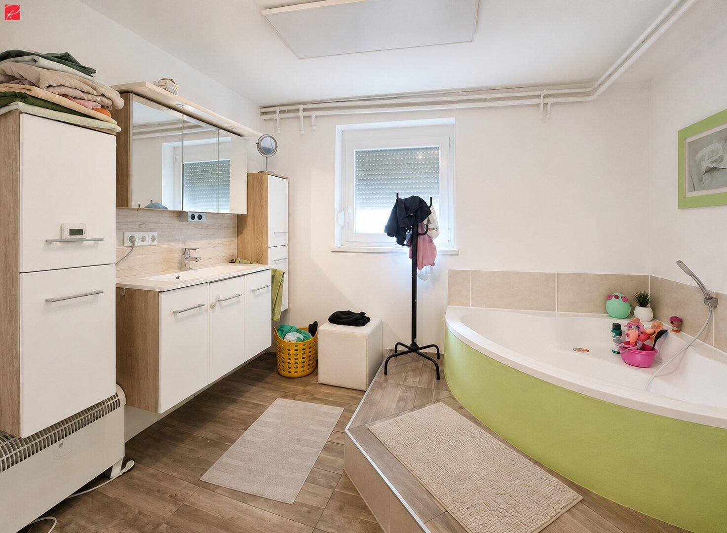 Funktionales Badezimmer mit Badewanne, Einzelwaschbecken und Fenster für Tageslicht.