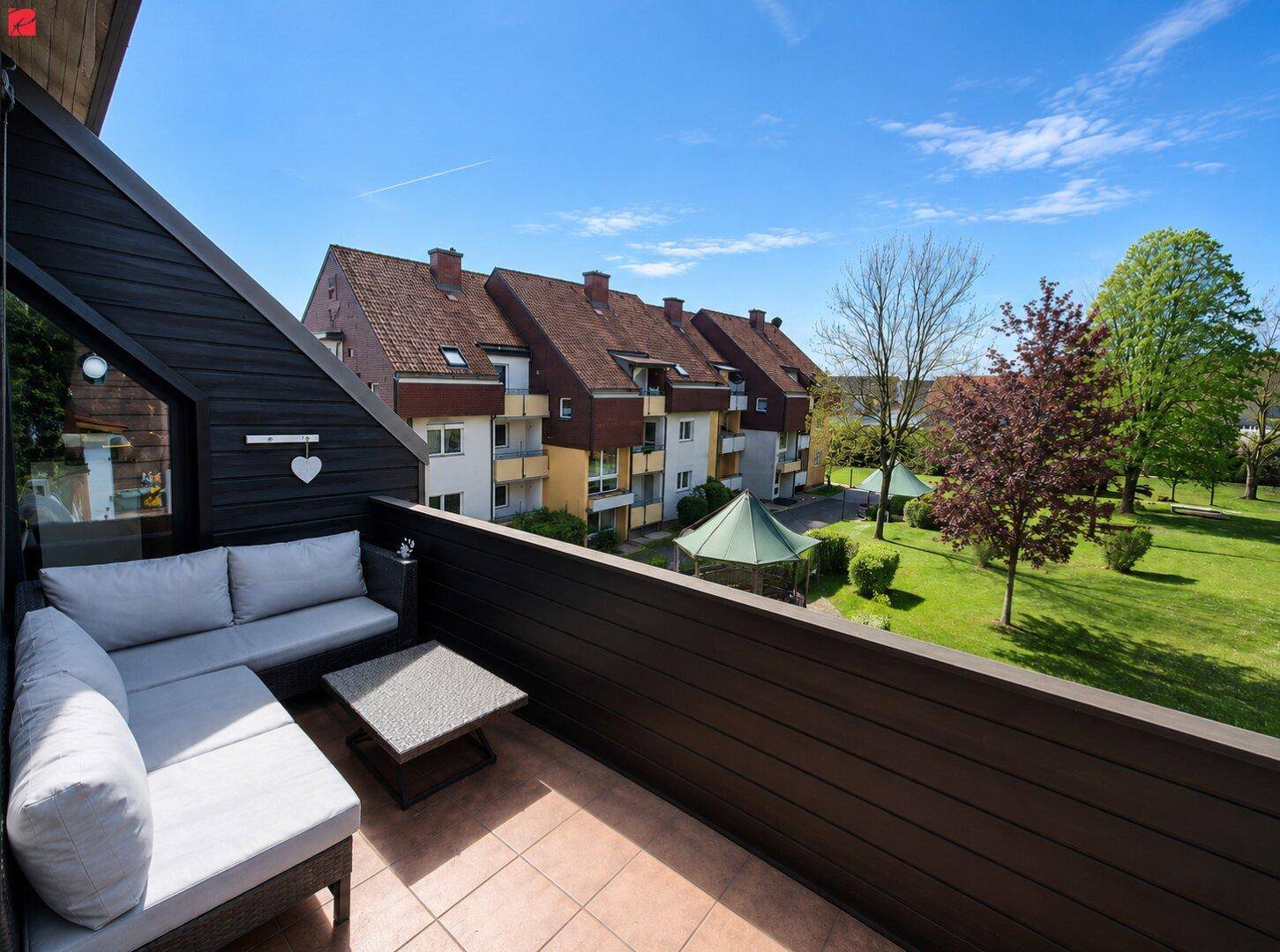 Geräumiger Balkon mit bequemen Gartenmöbeln und Blick auf die grüne Umgebung.