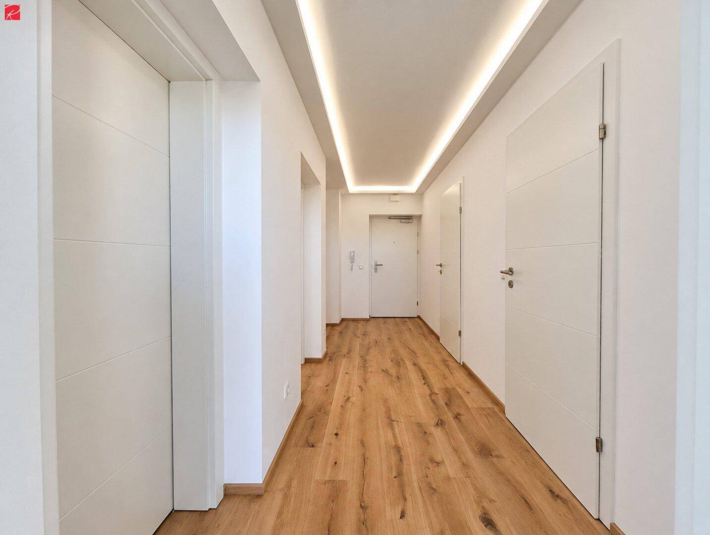 Heller Flur mit modernem Holzboden und integrierter Deckenbeleuchtung.