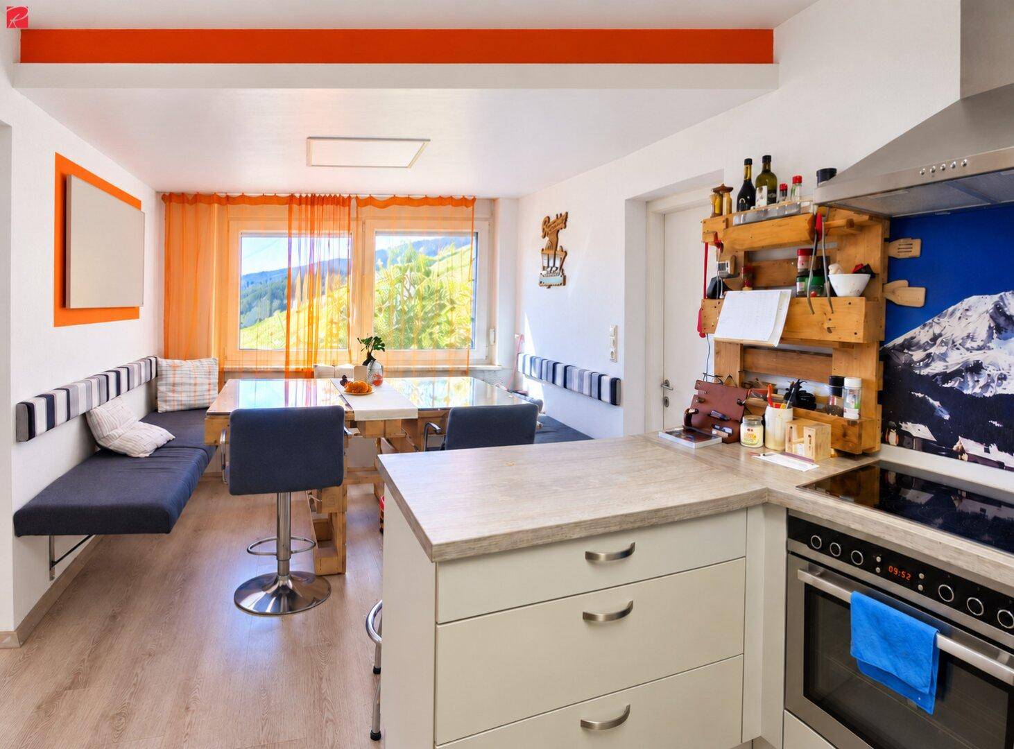 Gemütlicher Essbereich mit Sitzbank, Holztisch und weitem Blick auf die umliegende Berglandschaft.
