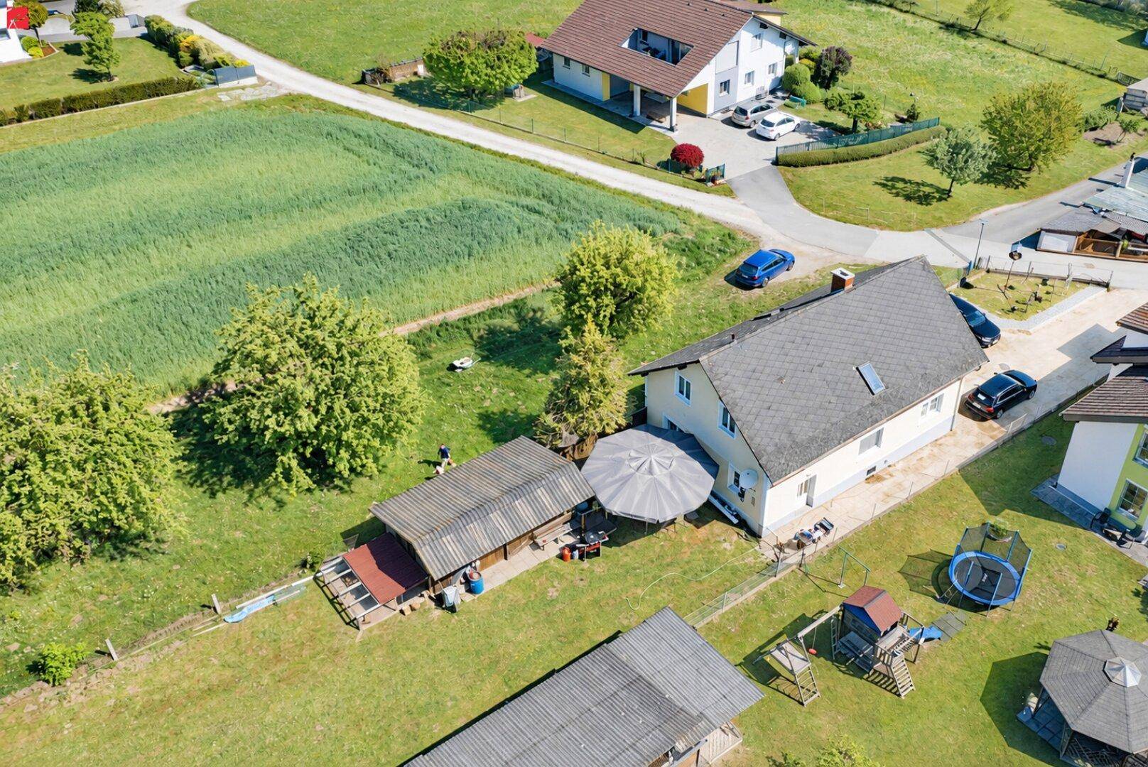 Luftaufnahme des Hauses mit großem Garten, Spielplatz und Trampolin in ländlicher Umgebung.