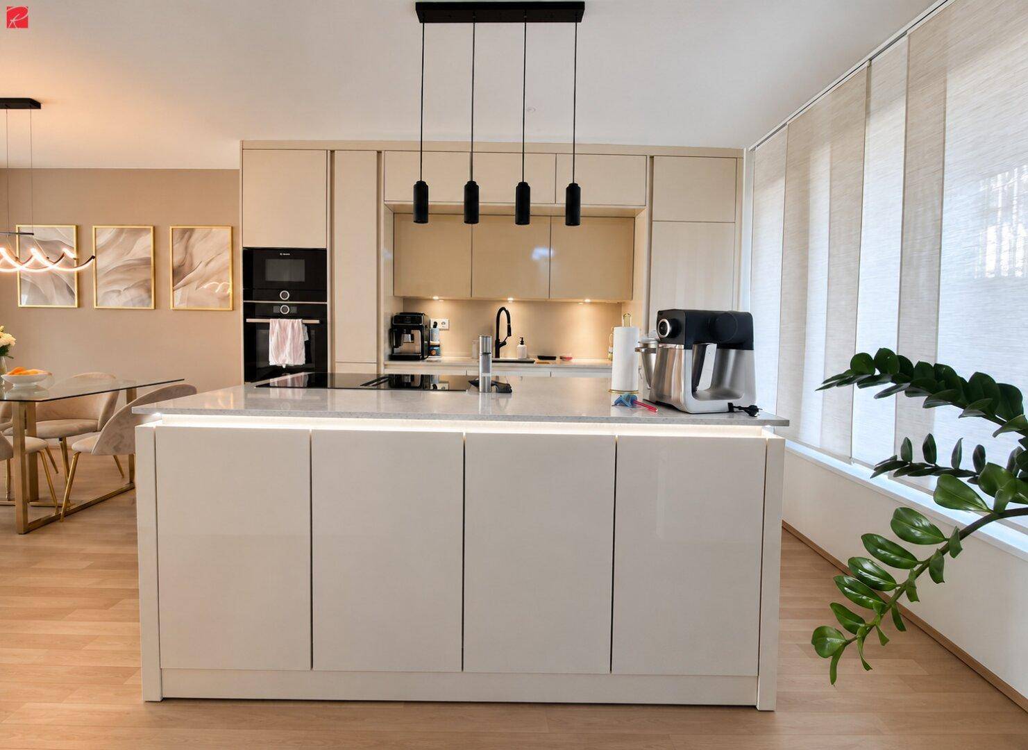 Moderne Küche mit Kücheninsel, integrierten Geräten und hellem Design.