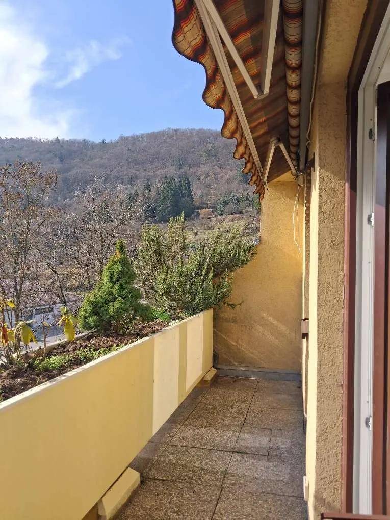 Geräumiger Balkon mit Fliesenboden, Markise und weitem Blick auf die bewaldeten Hügel und die Umgebung.