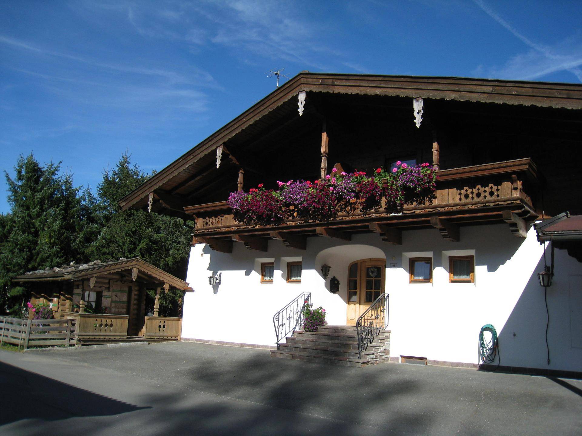 Traditionelles Chalet mit Holzbalkon, reich verziert und geschmückt mit bunten Blumenkästen.