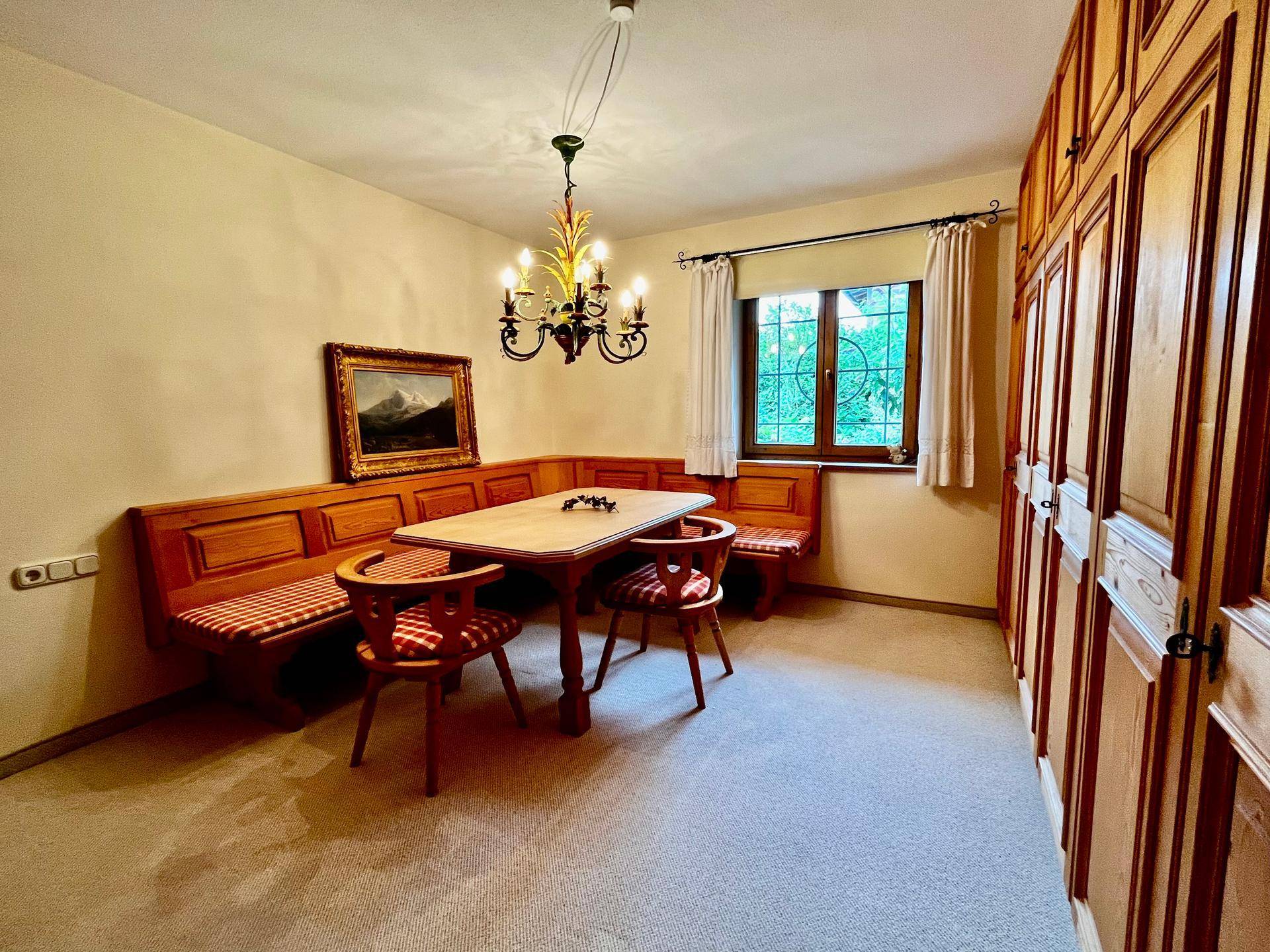 Traditioneller Essbereich mit Eckbank, Holztisch und integrierten Holzschränken, ideal für gesellige Runden.