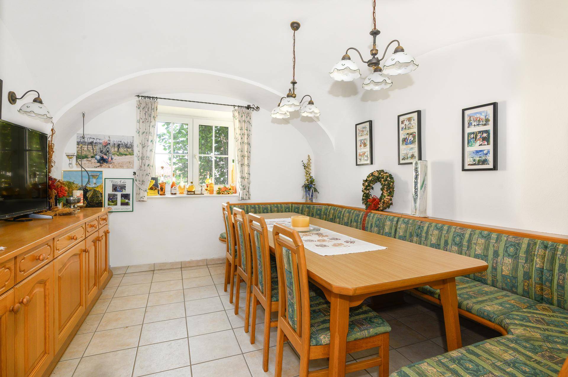 Traditioneller Essbereich mit großem Holztisch, Eckbank und Fenster, ideal für Familienmahlzeiten.