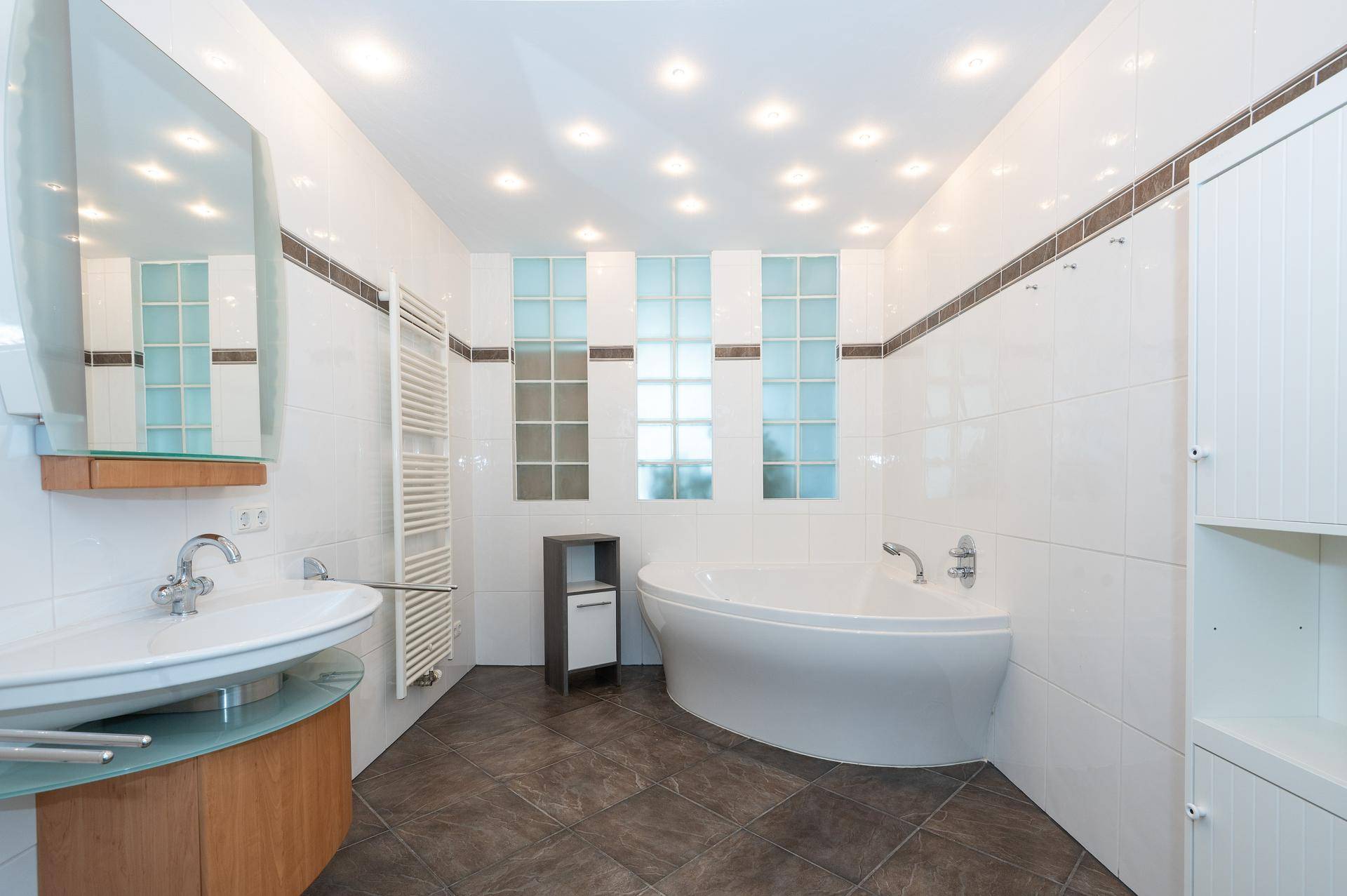 Modernes Badezimmer mit freistehender Badewanne, Einzelwaschbecken und Fliesen.