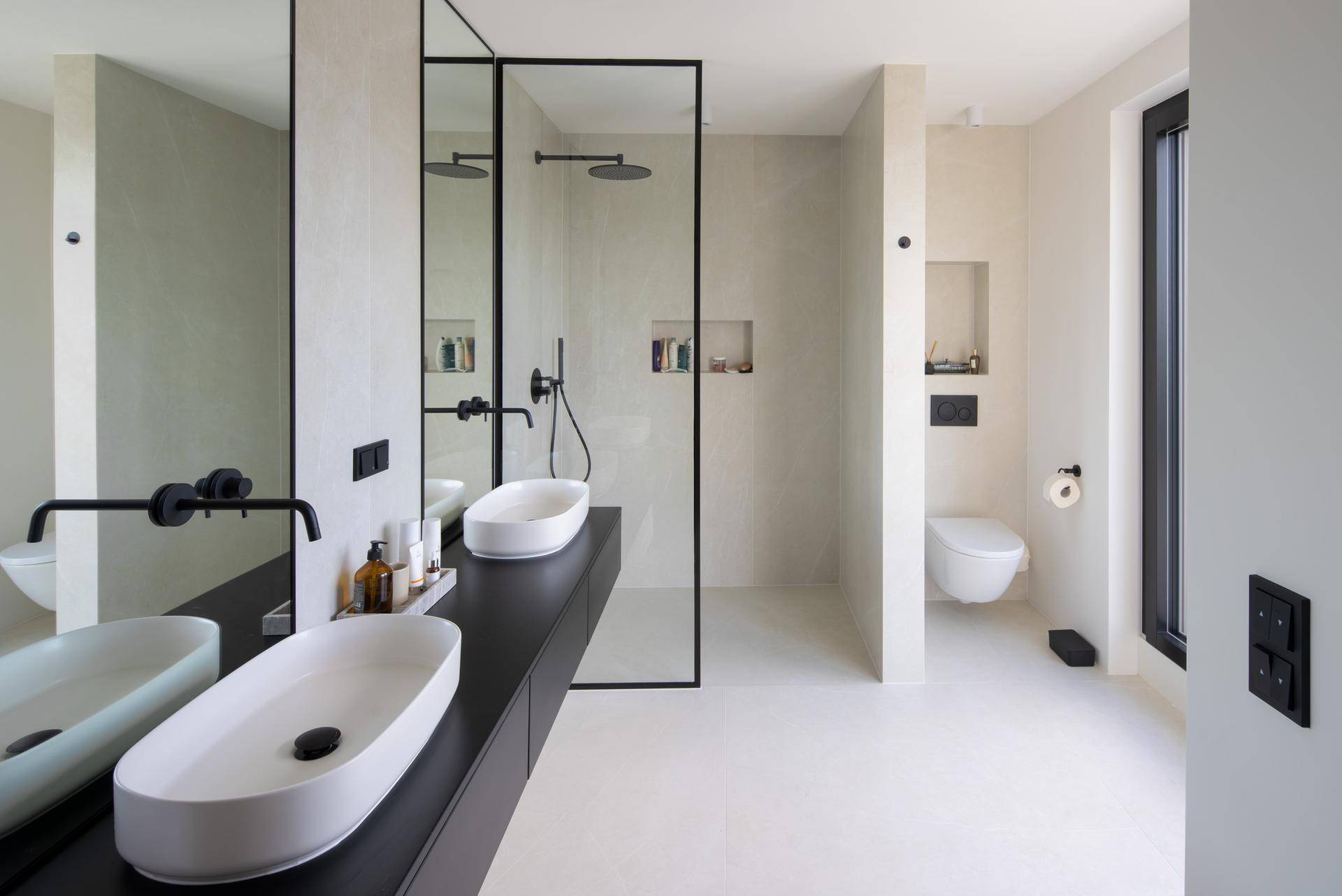 Modernes Badezimmer mit Doppelwaschbecken, großer begehbarer Dusche und Fenster.