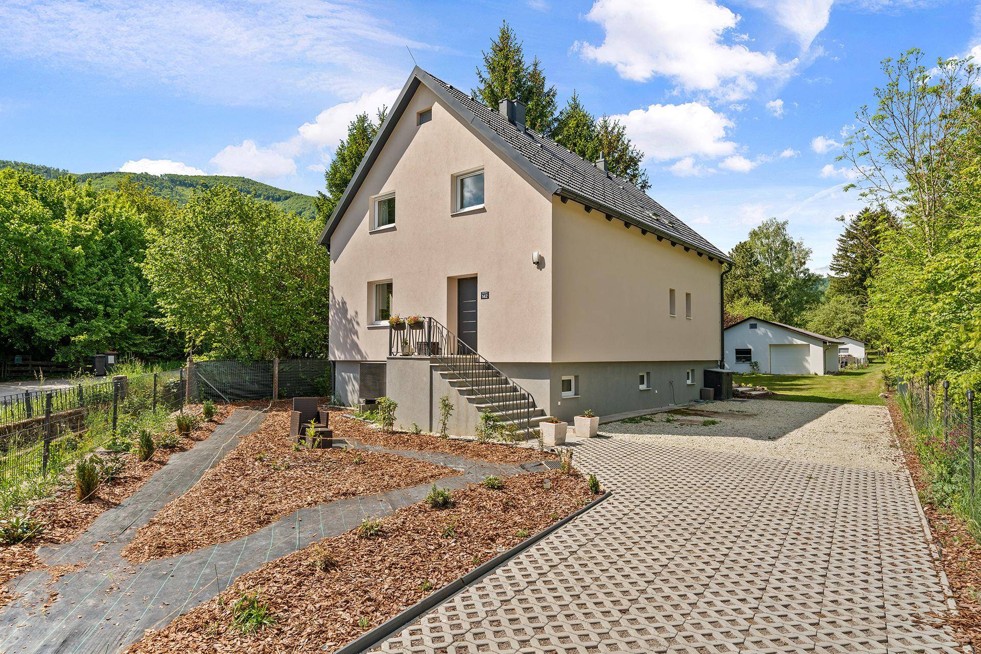 Freistehendes Einfamilienhaus mit gepflegter Fassade und Zufahrt.