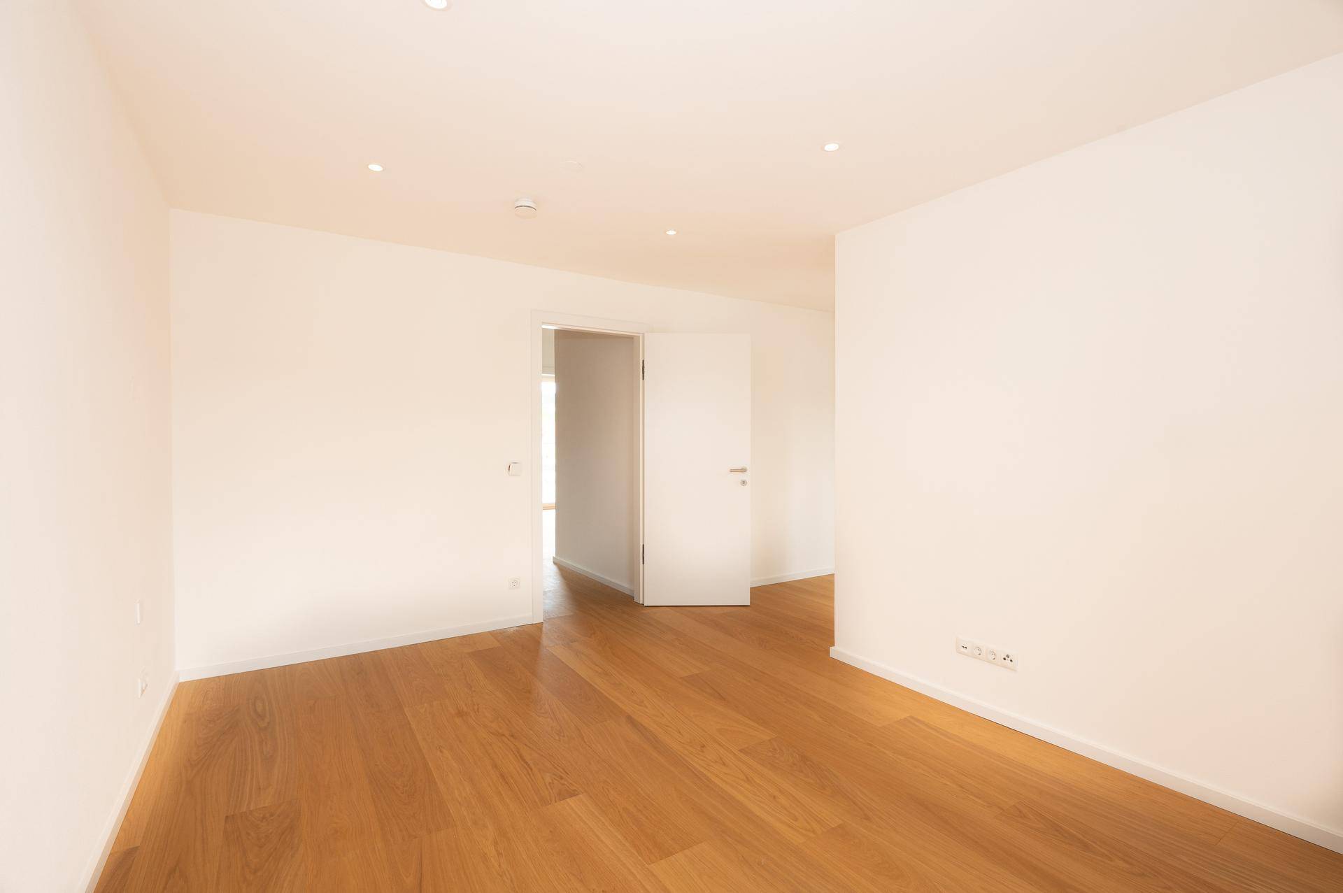 Geräumiges, helles Zimmer mit Eichenparkettboden und großem Fenster für viel Tageslicht.