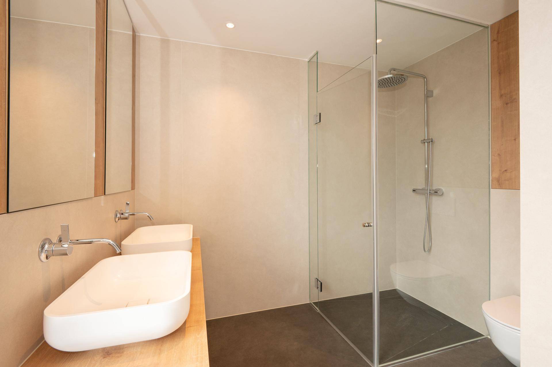 Elegantes Badezimmer mit Doppelwaschbecken, großer begehbarer Dusche und modernen Armaturen.